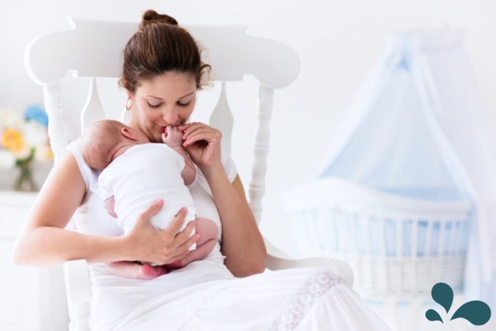 A new mother sits comfortably in a rocking chair, lovingly breastfeeding her newborn baby in a serene nursery setting.