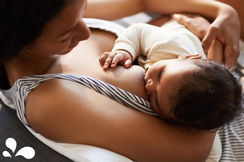 relaxed mother laid back while breastfeeding her baby, showcasing the comfort and ease of the bonding process.