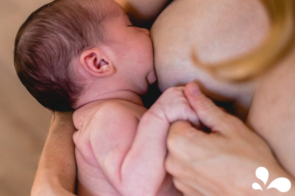 An infant breastfeeds skin-to-skin, emphasizing the natural and close connection between mother and child.
