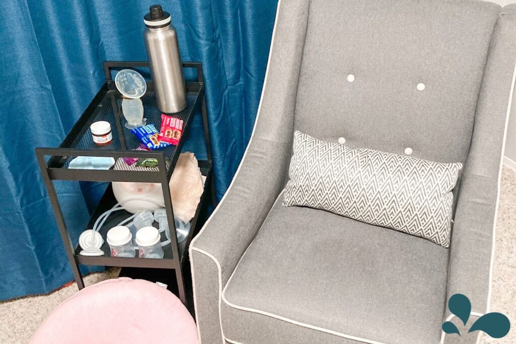 A well-organized nursing station with a comfortable chair, a side table stocked with breastfeeding supplies, snacks, and a water bottle, designed for convenience and comfort.