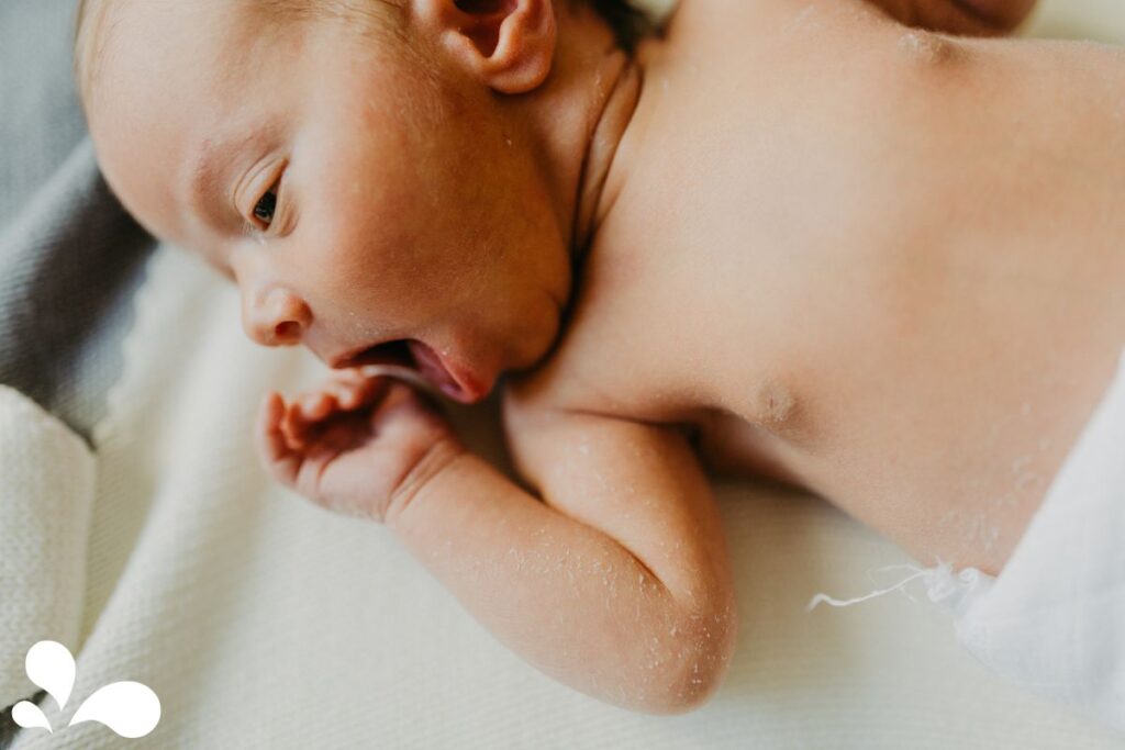 An infant turning their head to the side with an open mouth, showing a classic hunger cue known as rooting.