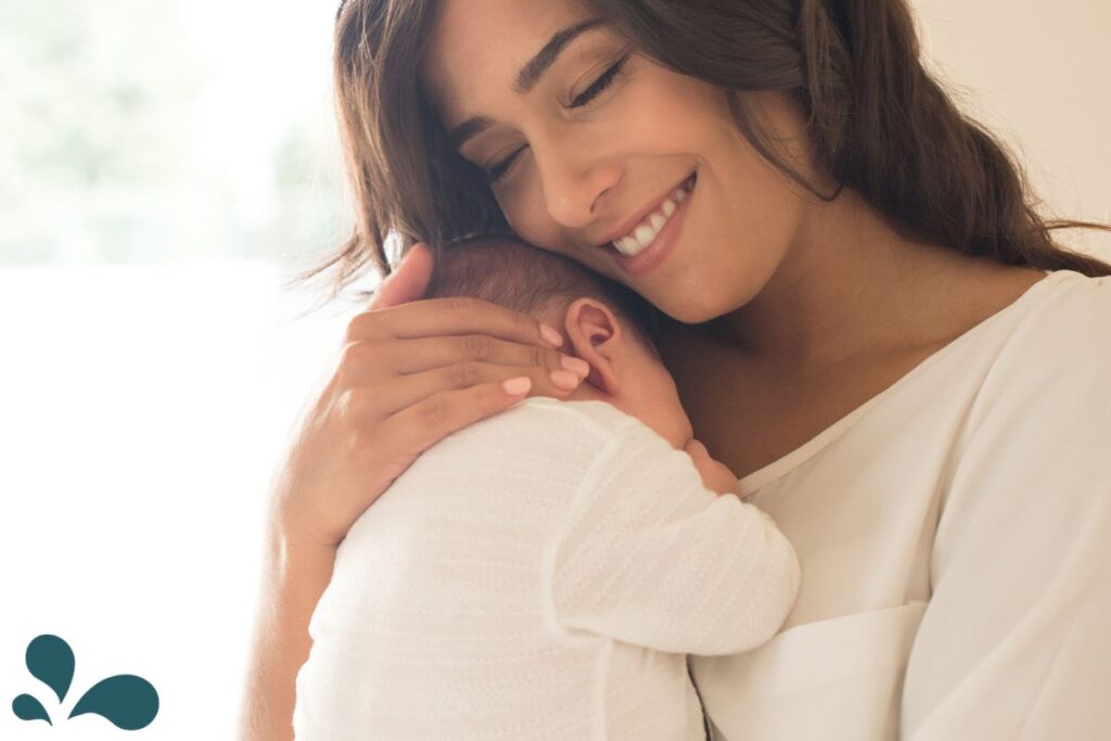 A serene moment with a mother holding her sleeping newborn close to her chest in a cozy home setting.