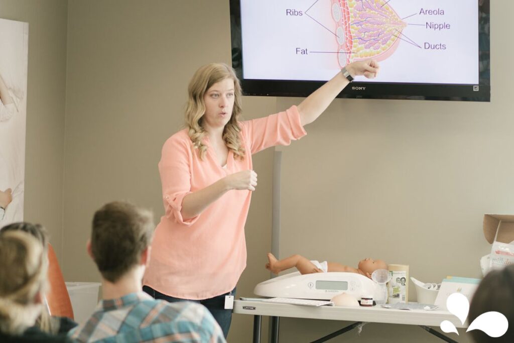 An IBCLC, Anna Burch, teaching a room of expecting parents about the anatomy of the breast in preparation to understanding the breastfeeding process.