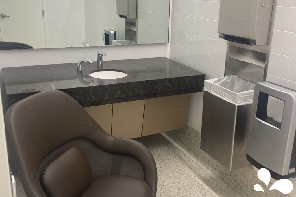 A cozy brown armchair placed beside a countertop with a sink, providing a clean and private space for breastfeeding or pumping.