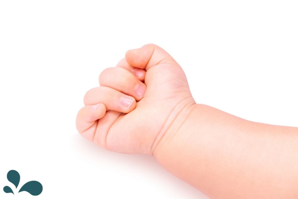 A close-up image of a baby's small, clenched fist against a pure white background, symbolizing the delicate and pure essence of new life