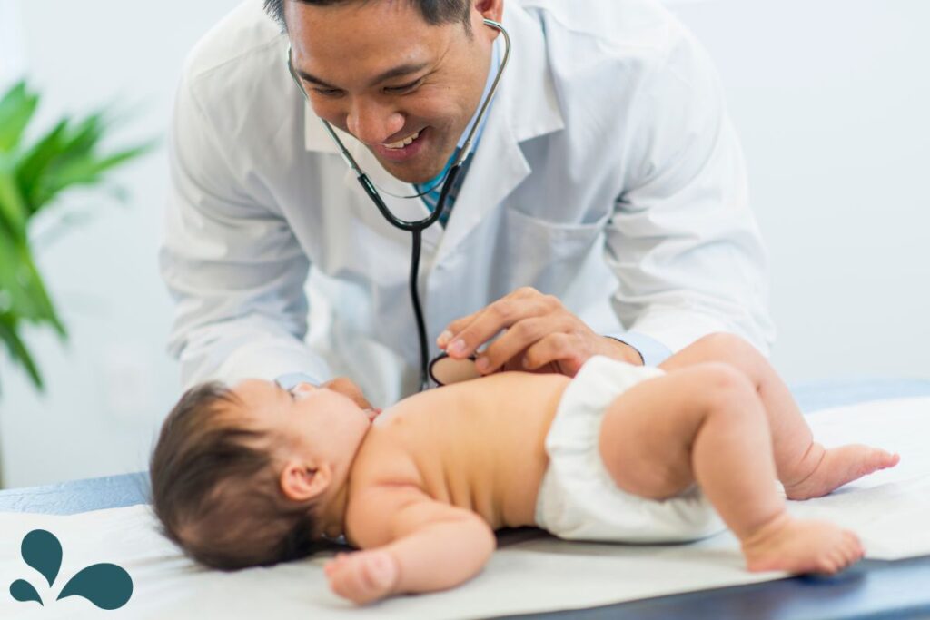 A friendly pediatrician interacts with an infant during a routine health check.