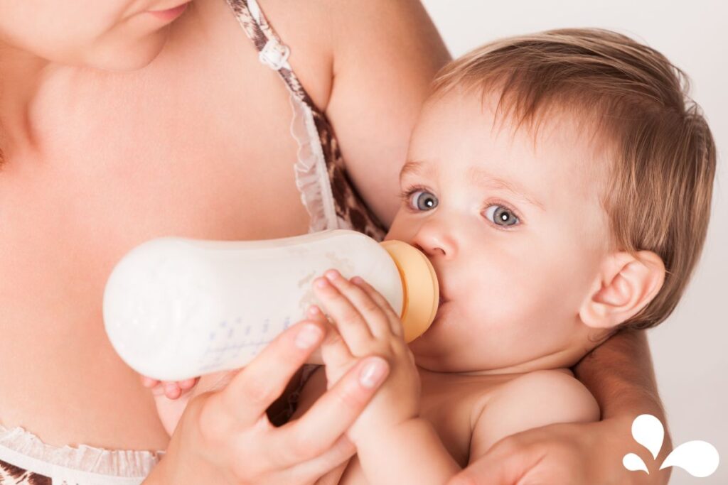 A gentle moment captured as a woman bottle-feeds a baby, showcasing the intimate and caring bond between caregiver and child.
