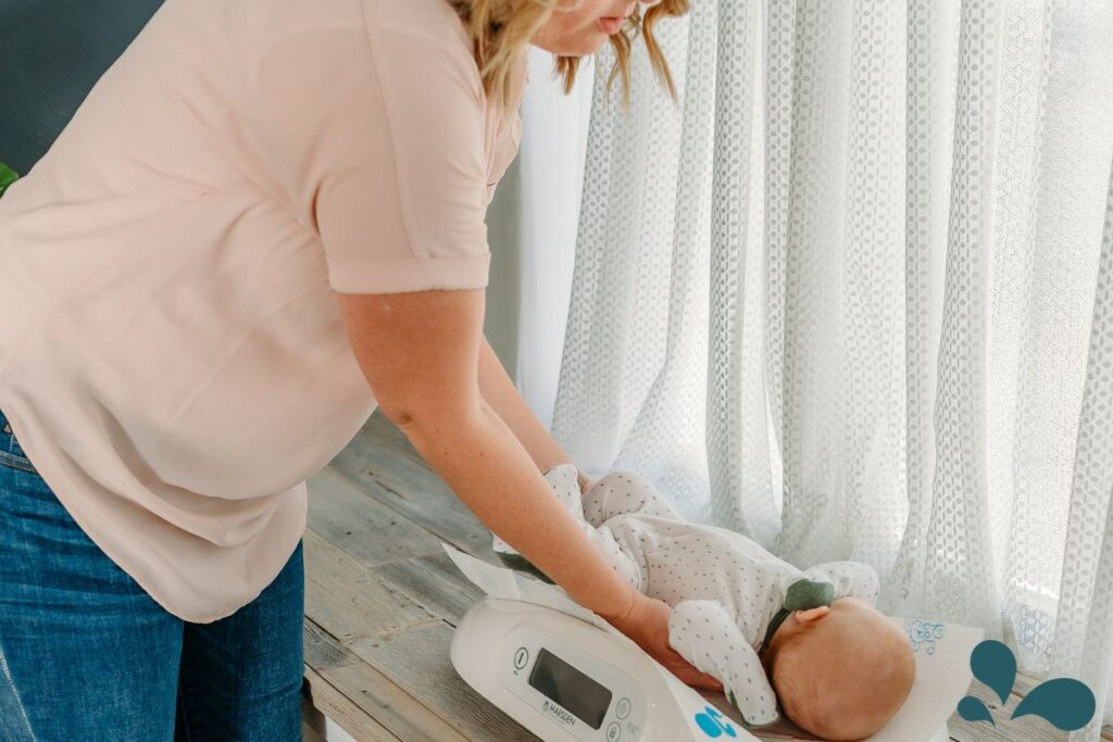 A mother attentively placing her baby on a modern infant scale to monitor the baby's weight gain, a critical aspect of early childhood health.