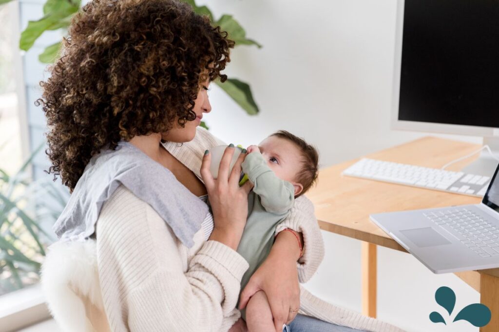 A mother comfortably seated, bottle-feeding her content baby, showcasing an alternative feeding method embraced by parents.