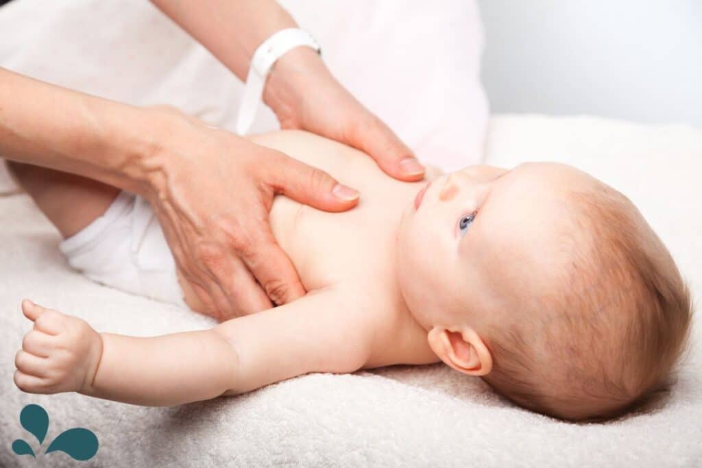 A baby having its chest massaged.