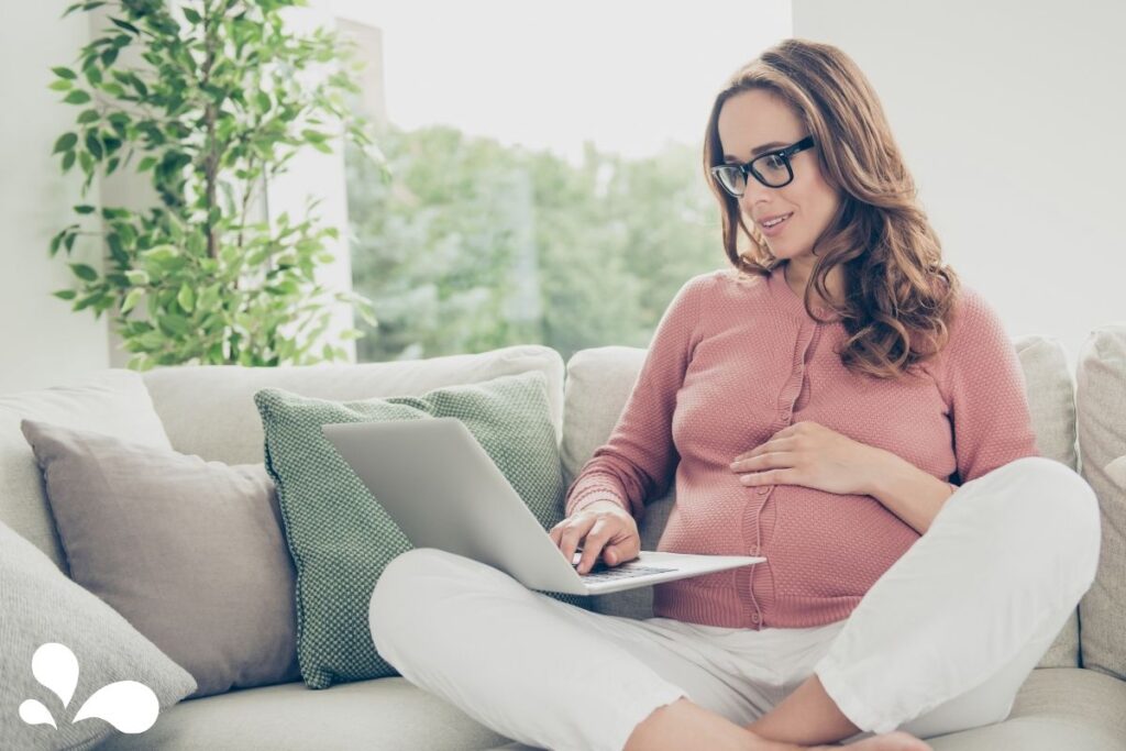 A pregnant woman at a laptop